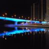 Ночной мост через реку. ослепительная иллюминация подсвечивает мост. Ночная подсветка освещает контур моста, выгодно подчеркивая все его достоинства. Архитектура моста современная. Конструкция моста разработана с учетом современных