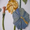 Мозаичная плитка. Узор из керамики нанесен на основание. Рисунок наносится и закрепляется методом запекания. Преобладают цветы голубого цвета и голубовато- зеленого оттенка. На заднем плане располагается цветок оранжевого цвета.